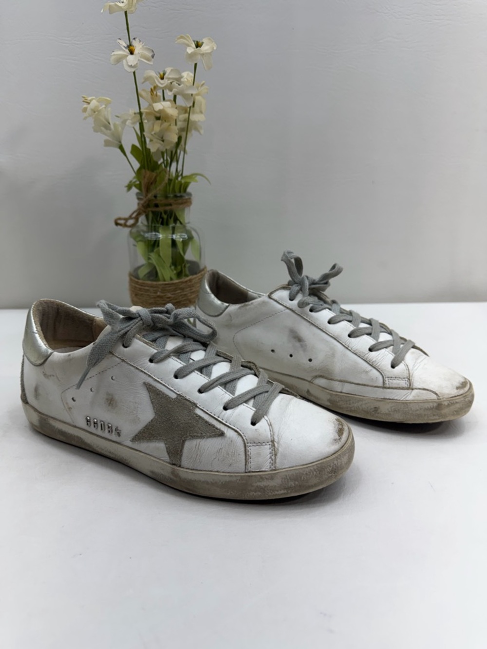 Golden Goose Deluxe Brand Super-Star sneakers in a white and silver colorway.